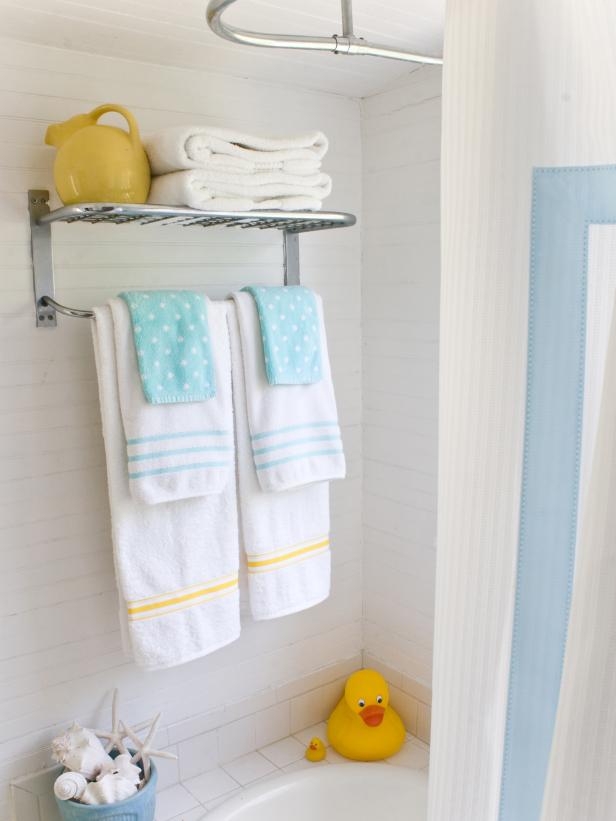 Hang a shelf with colorful, patterned towels to brighten up the bathroom